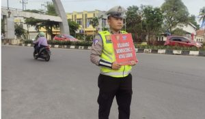 Satuan Lalu Lintas Polres Prabumulih melaksanakan pengaturan arus lalu lintas dengan membawa papan bicara