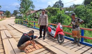 Anggota Polsek Serawai Bersama Warga Gotong Royong Memperbaiki Jembatan Yang Berlubang Di Kecamatan Serawai