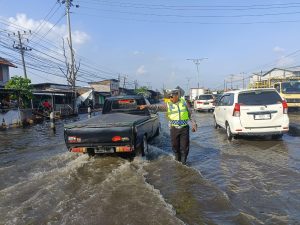 Aksi Anggota Lantas Polres Demak Lakukan Pengaturan Arus Lalin di Lokasi Banjir Rob