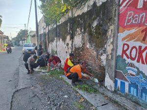 Bhabinkamtibmas Ketelan Bersama Warga Kompak Bersihkan Rumput Liar di Jalan